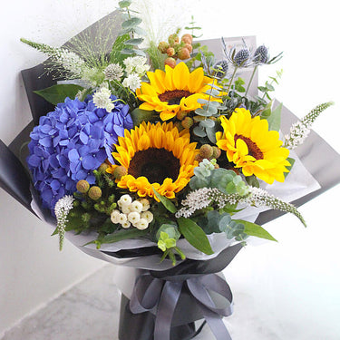 Blooming Beauty, Mixed Flowers Beautifully Wrapped Bouquet, Sun Flower, Blue Hydrangea, White Wax, Eryngium, White Veronica, Tanacetum, Eucalyptus, Ruscus, Beautifully Wrapped